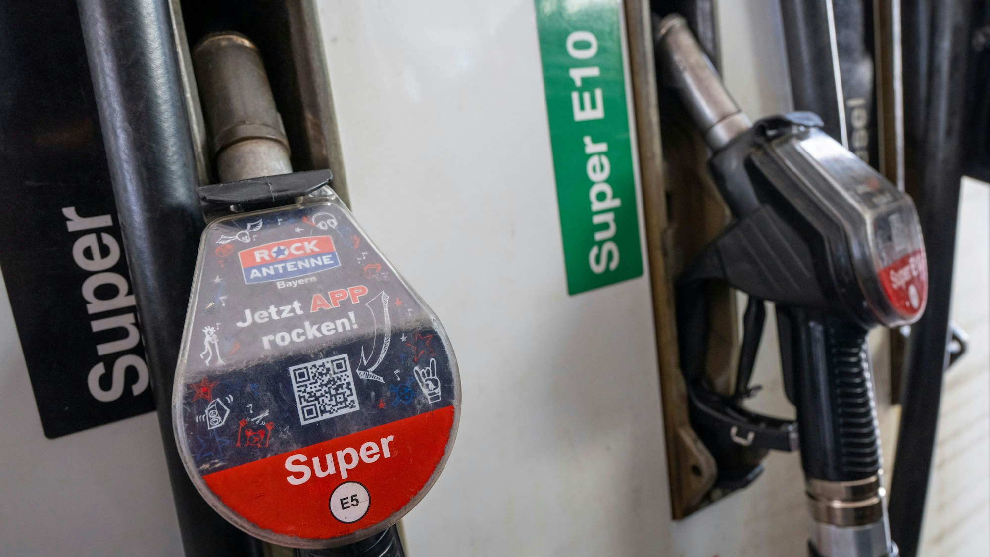 Zapfpistolen hängen an einer Tankstelle. (Symbolbild) Der Krieg im Nahen Osten hat Auswirkungen auf den Tankpreis.