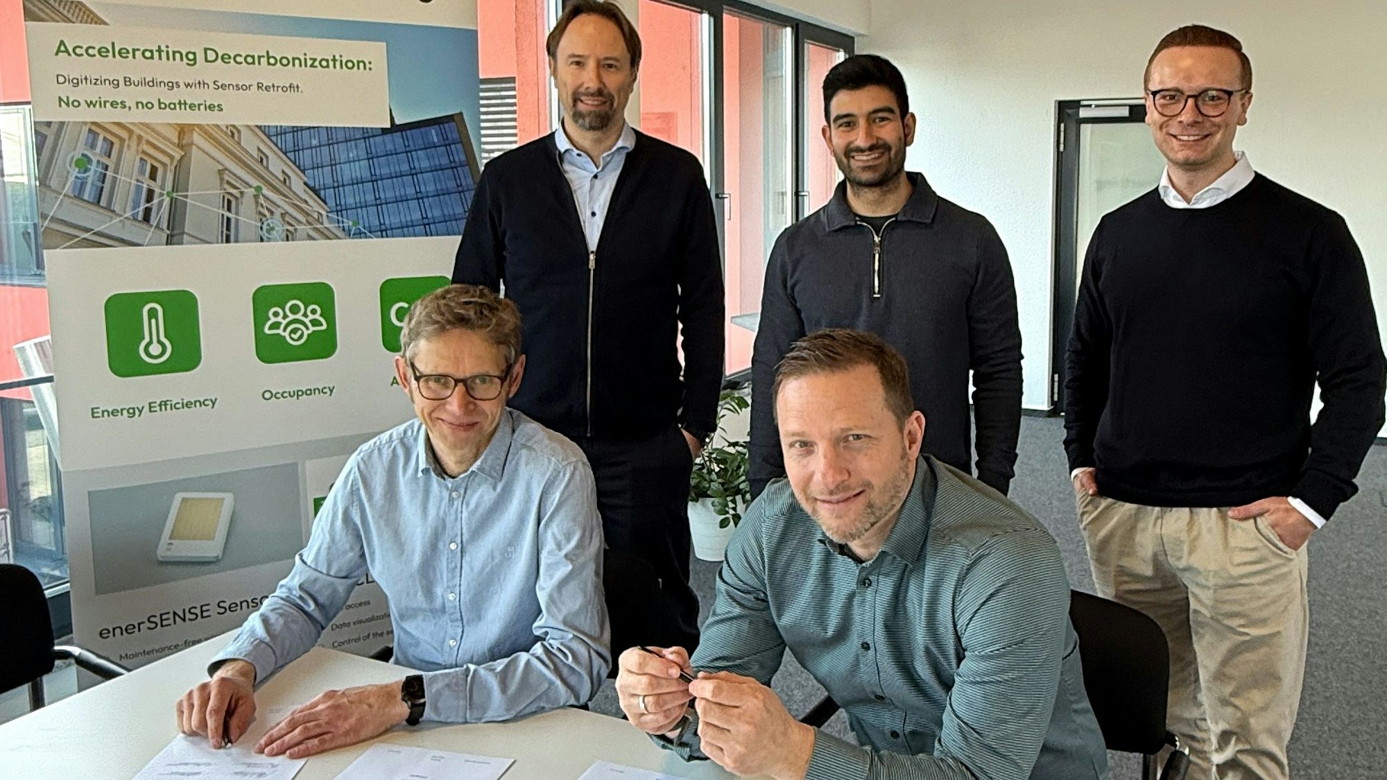 Michael Niggemann unterzeichnet mit Michael Franz von Currenta Conneqtive den Partnerschaftsvertrag zur Digitalisierung von Bestandsgebäuden. Christian Haase, Murat Mutlu und Konstantin Fonk schauen zu.