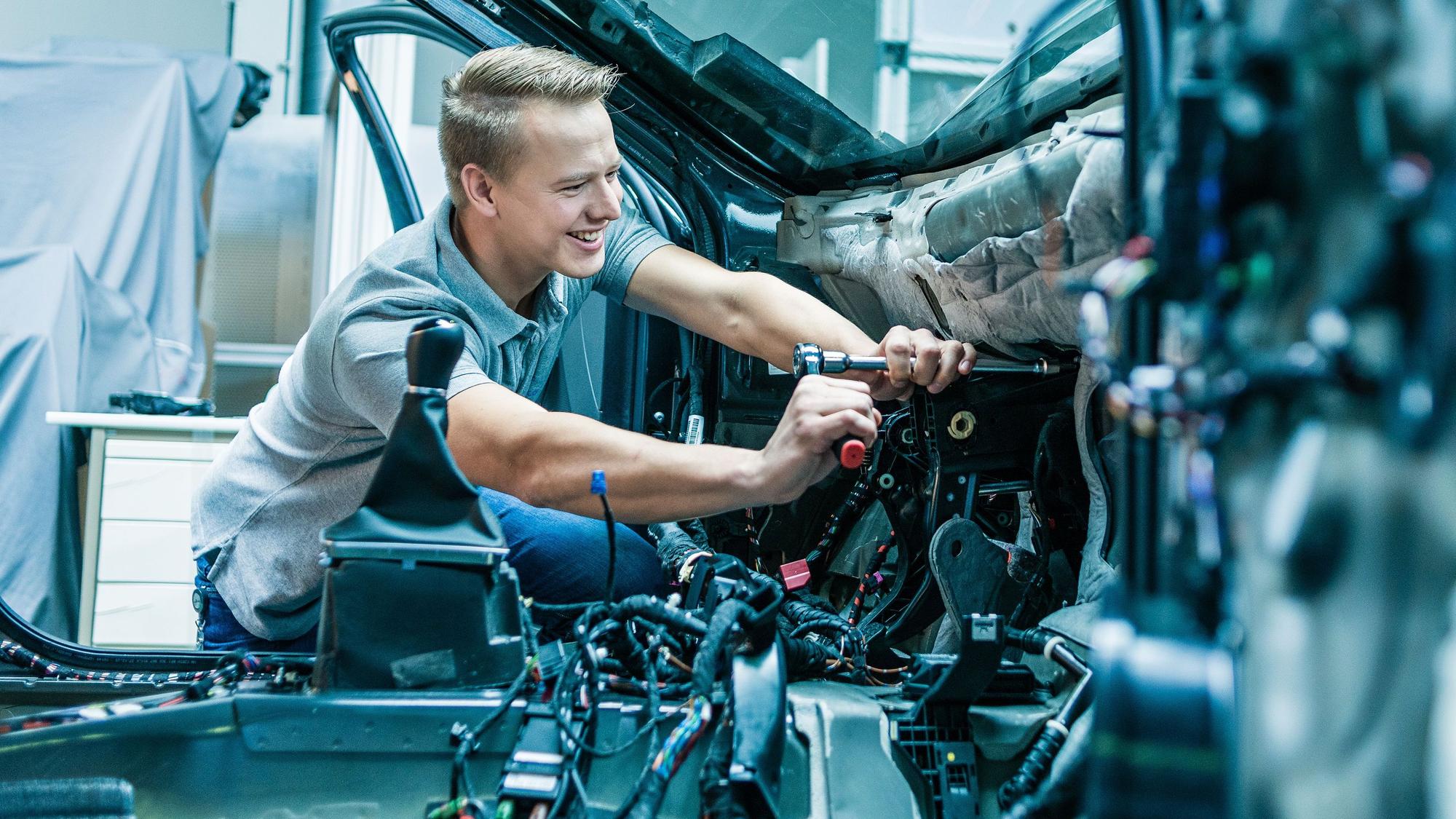 Ein Mann arbeitet im Innenraum eines Autos.