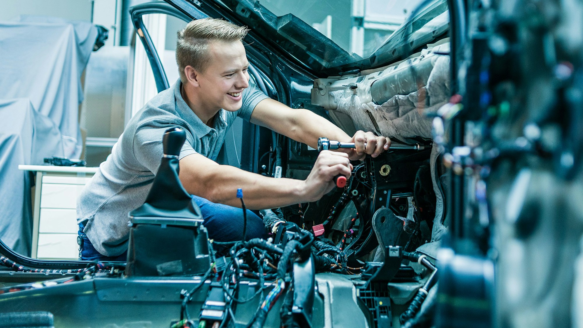 Ein Mann arbeitet im Innenraum eines Autos.