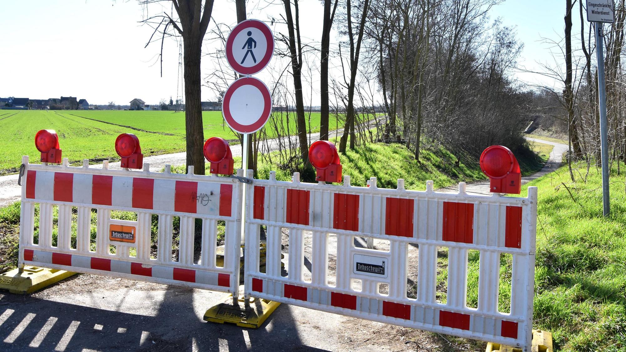 Eine Absperrung steht an einem Weg.