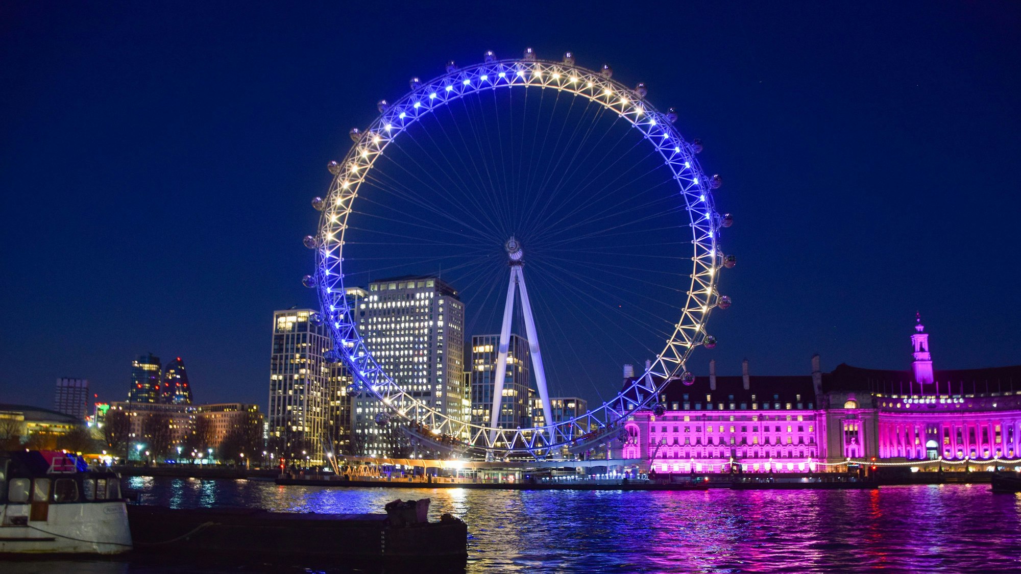 Das „London Eye“ an der Themse bei Nacht.