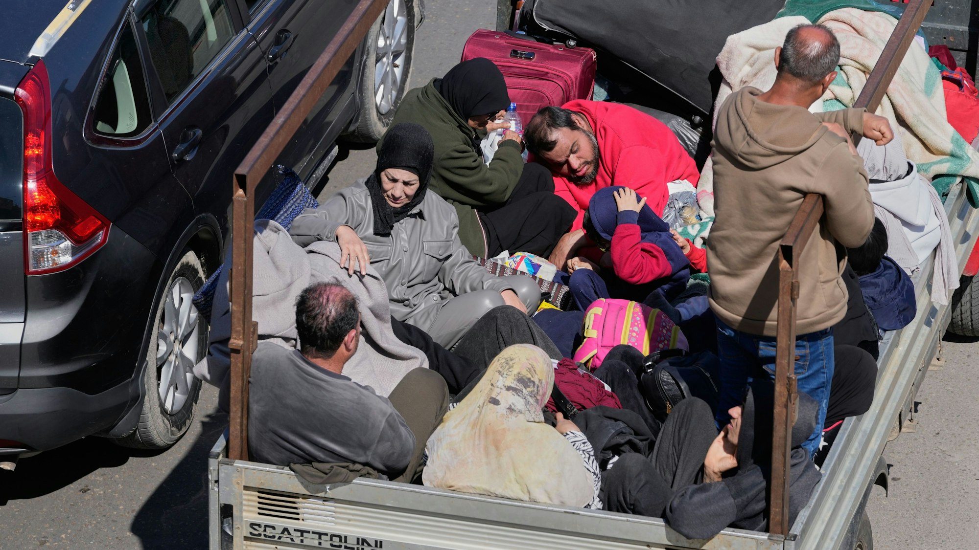 Eine Familie, die vor israelischen Luftangriffen im Südlibanon flieht, sitzt auf einem Pickup auf einer Autobahn in Richtung Beirut.