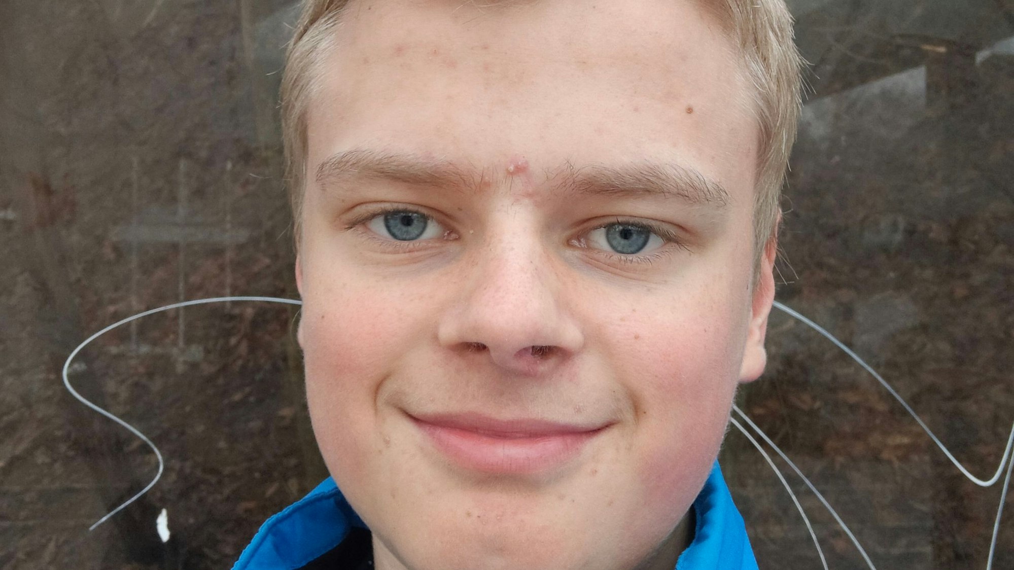 Ein junger Mann lächelt in die Kamera.