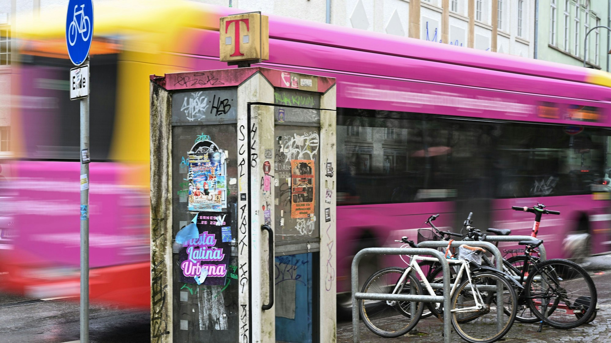 Eine stillgelegte, von Aufklebern, Plakaten und Graffiti übersäte, Telefonzelle der Telekom