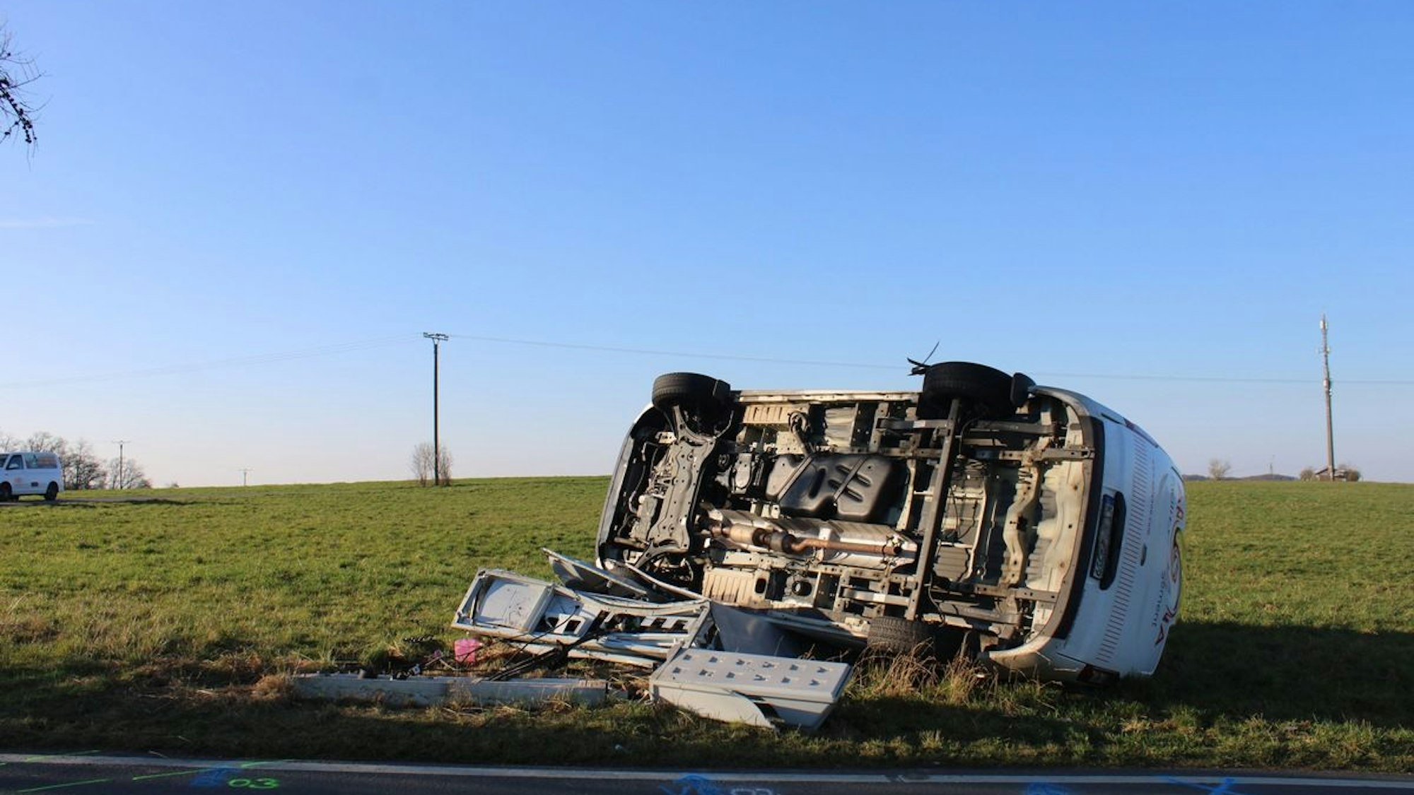 Ein umgekipptes Auto liegt nach einem Unfall auf einer Wiese. (Symbolbild)