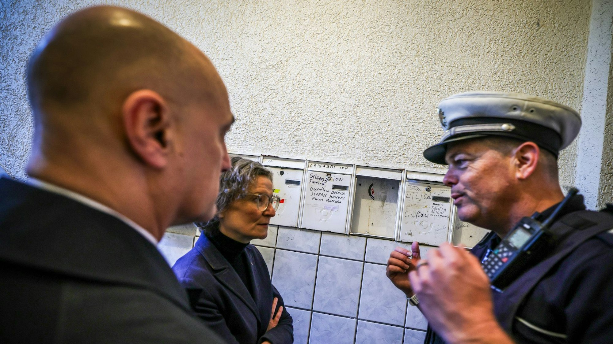 Alexander Kalouti (CDU, l), Oberbürgermeister der Stadt Dortmund, und Ina Scharrenbach (CDU, M), Ministerin für Heimat, Kommunales, Bau und Digitalisierung des Landes Nordrhein-Westfalen, nahmen an einer Kontrollaktion gegen Sozialbetrug in Schrottimmobilien teil und ließen sich von einem Polizeibeamten über die Situation aufklären.