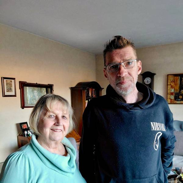 Eine Frau und ein Mann stehen in einem Wohnzimmer.