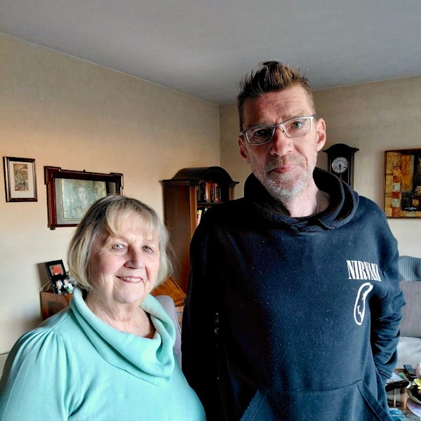 Eine Frau und ein Mann stehen in einem Wohnzimmer.