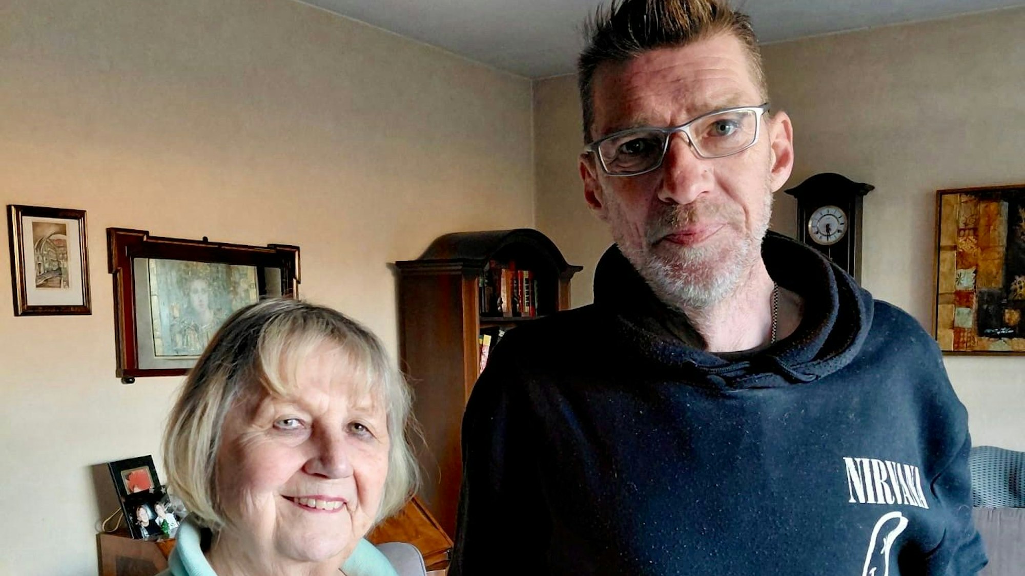 Eine Frau und ein Mann stehen in einem Wohnzimmer.