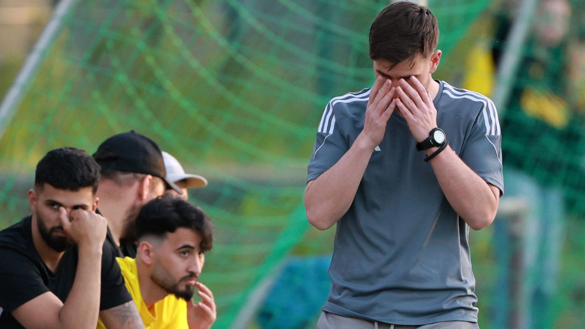 Das Bild zeigt den Trainer Marc Diamante, der mit den Händen sein Gesicht verdeckt.