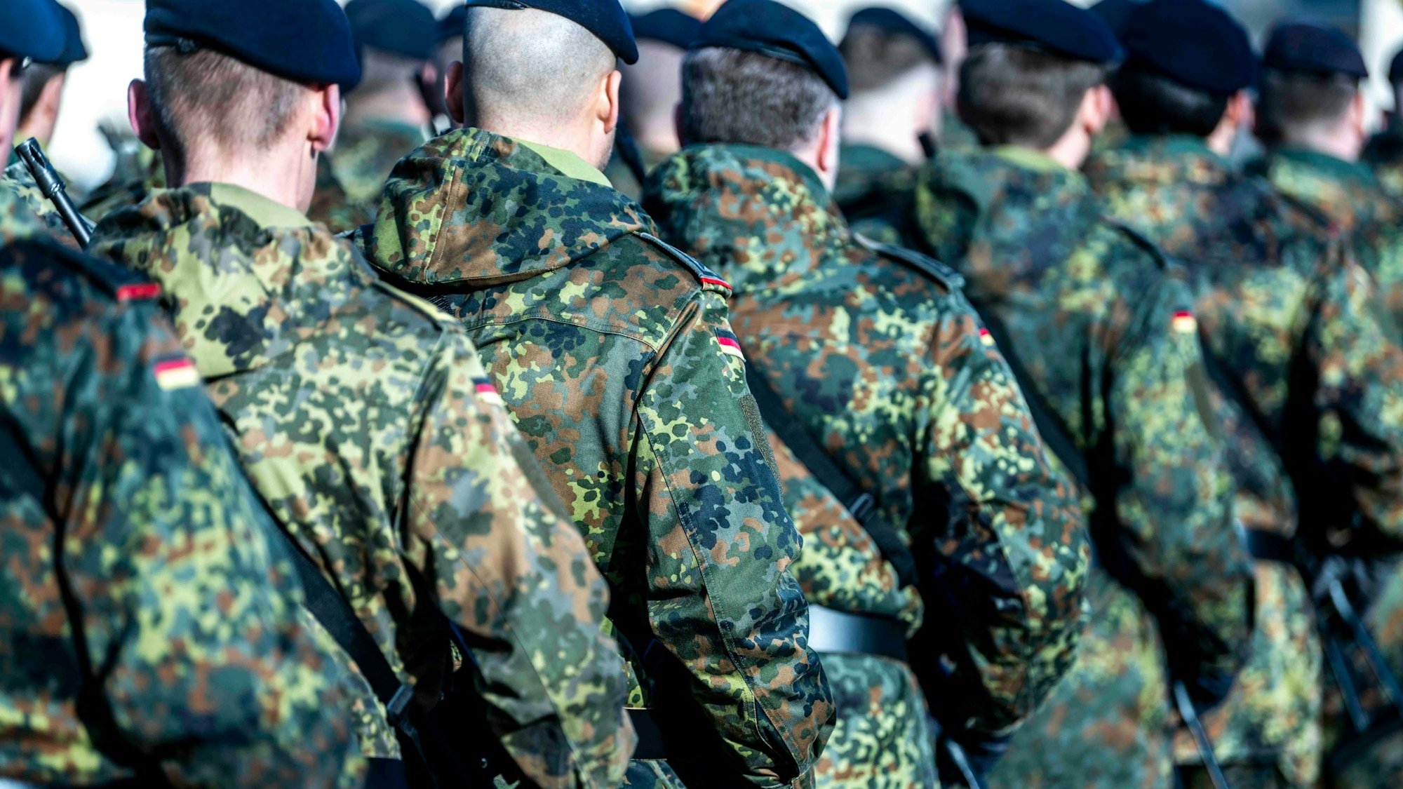 Eine Gruppe Soldaten marschiert hintereinander.
