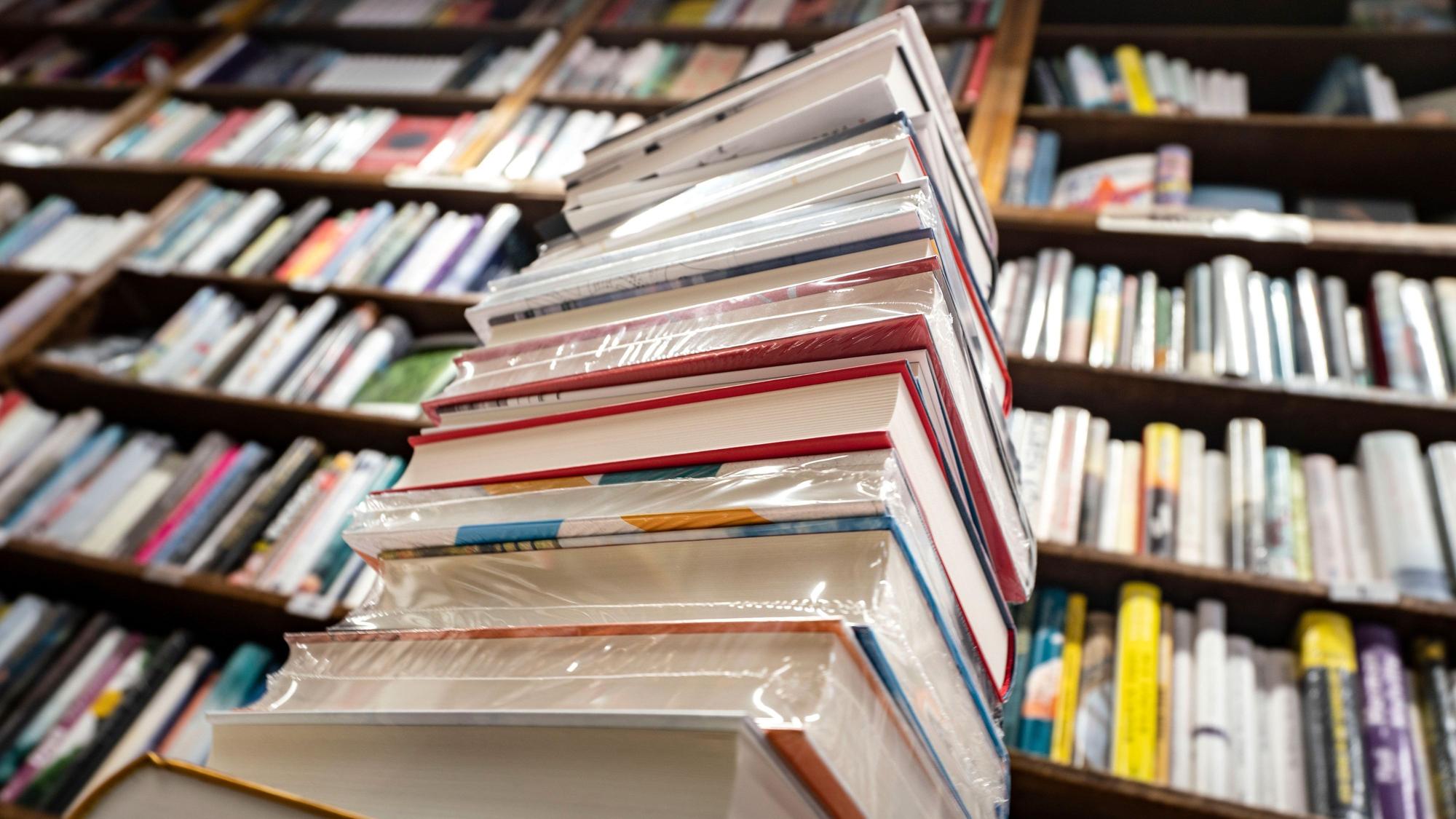 Ein Stapel neuer Bücher liegt auf einem Verkaufstisch in einer Buchhandlung. (zu dpa Kochbuch top, Reiseführer flop - Corona beeinflusst Buchmarkt) +++ dpa-Bildfunk +++