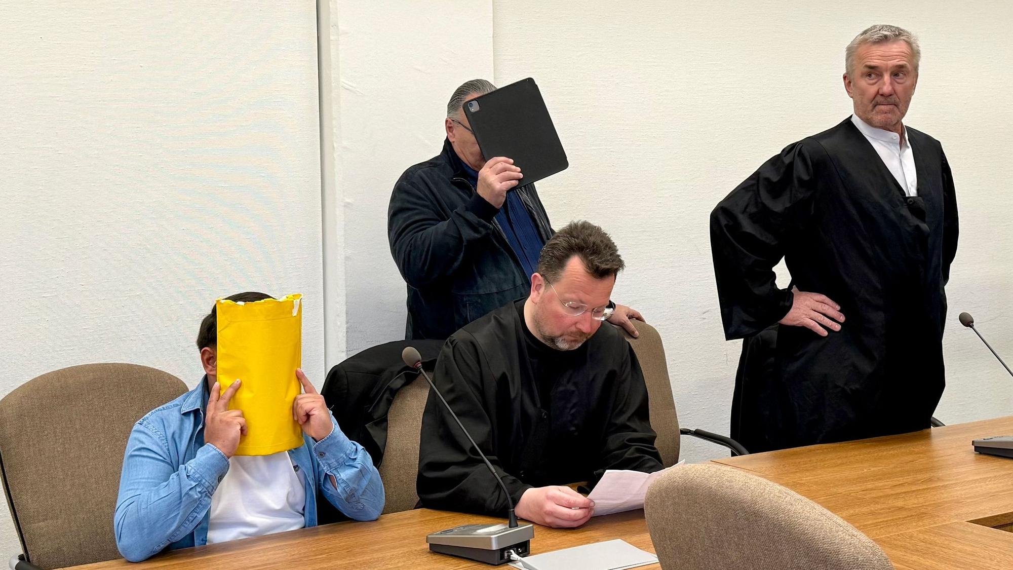 Zwei Angeklagte mit verdeckten Gesichtern und ihre beiden Anwälte Philipp Thiée und Markus Bündgens