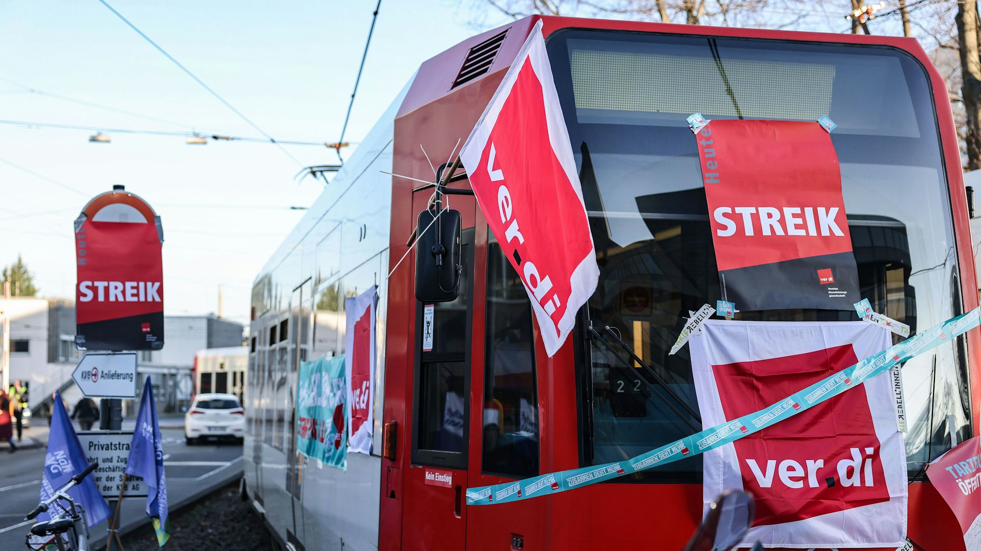 Eine mit Streik-Plakaten beklebte Straßenbahn der Kölner Verkehrs-Betriebe (KVB) steht vor dem Bahndepot.