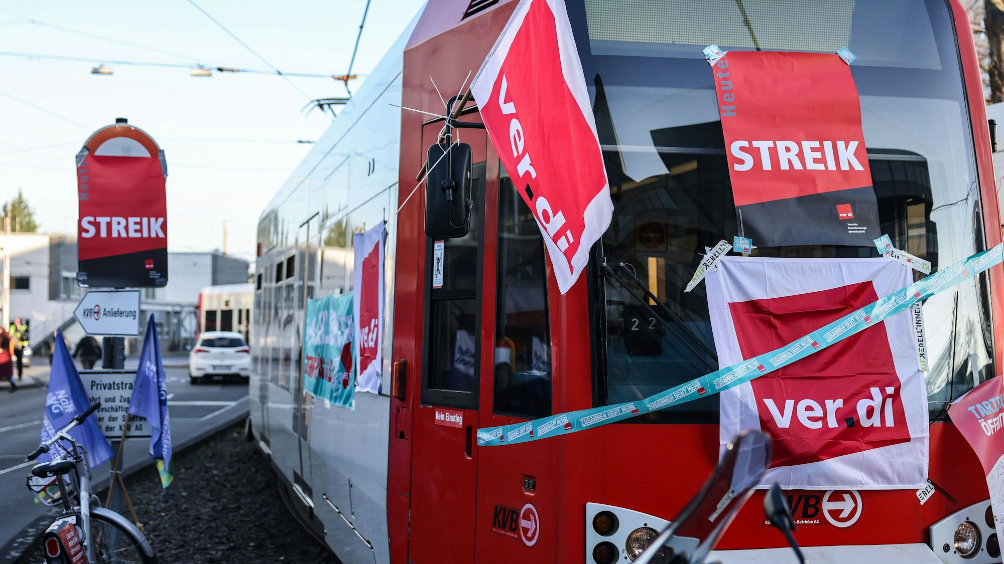 Eine mit Streik-Plakaten beklebte Straßenbahn der Kölner Verkehrs-Betriebe (KVB) steht vor dem Bahndepot. (Symbolbild)