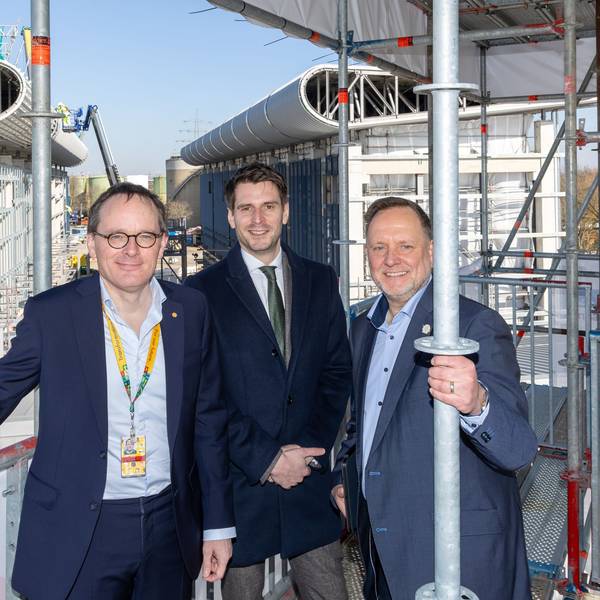 NRW-Staatssekretär Paul Höller (Mitte) besichtigt den unfertigen Bau des Wasserstoff-Elektrolyseurs gemeinsam mit den Shell-Managern Jan-Peter Groot Wassink und Jens Müller-Belau im Energie- und Chemiepark Wesseling.
