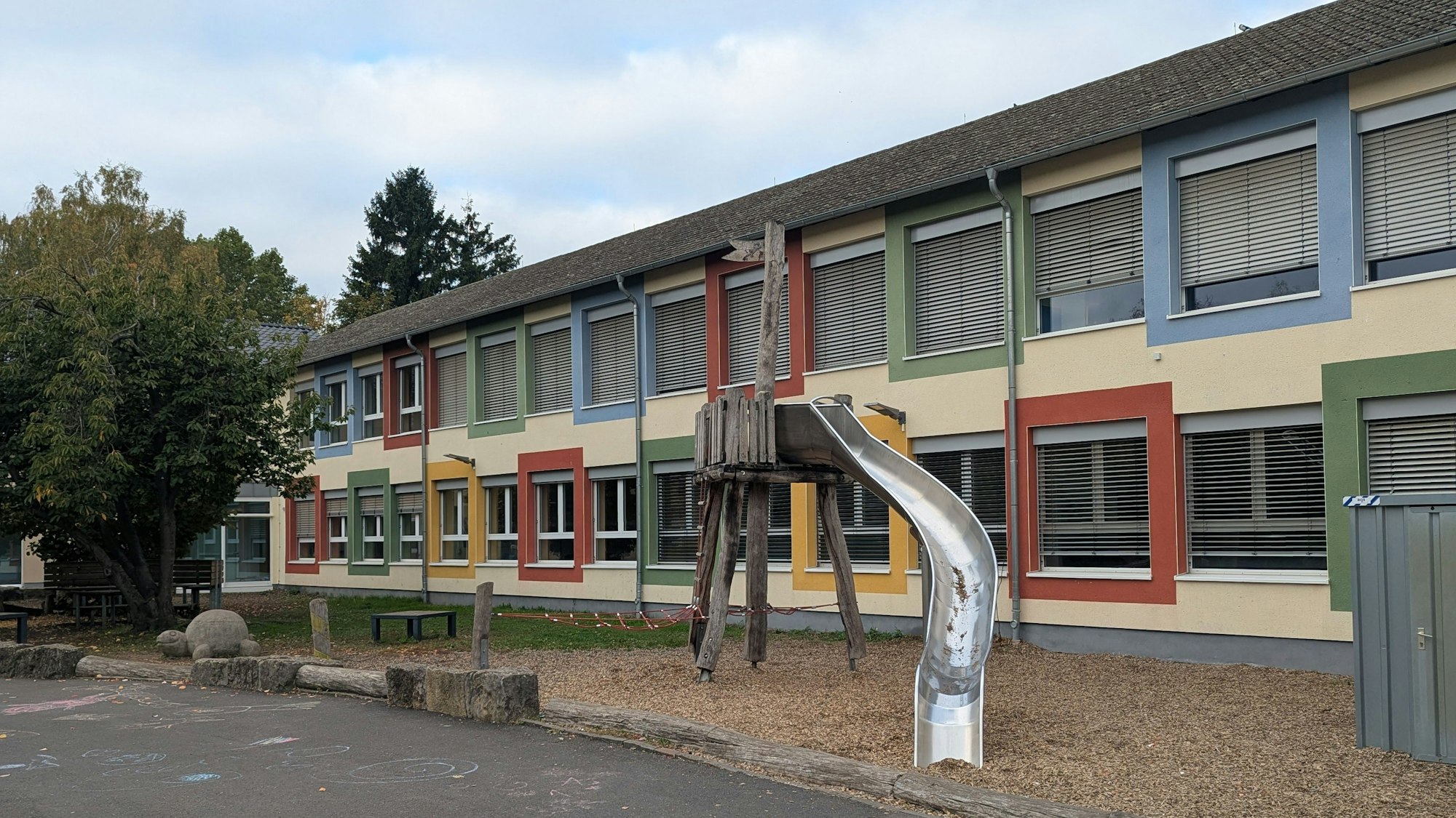 Das Foto zeigt eine Außenaufnahme der Schule und des Schulhofs.