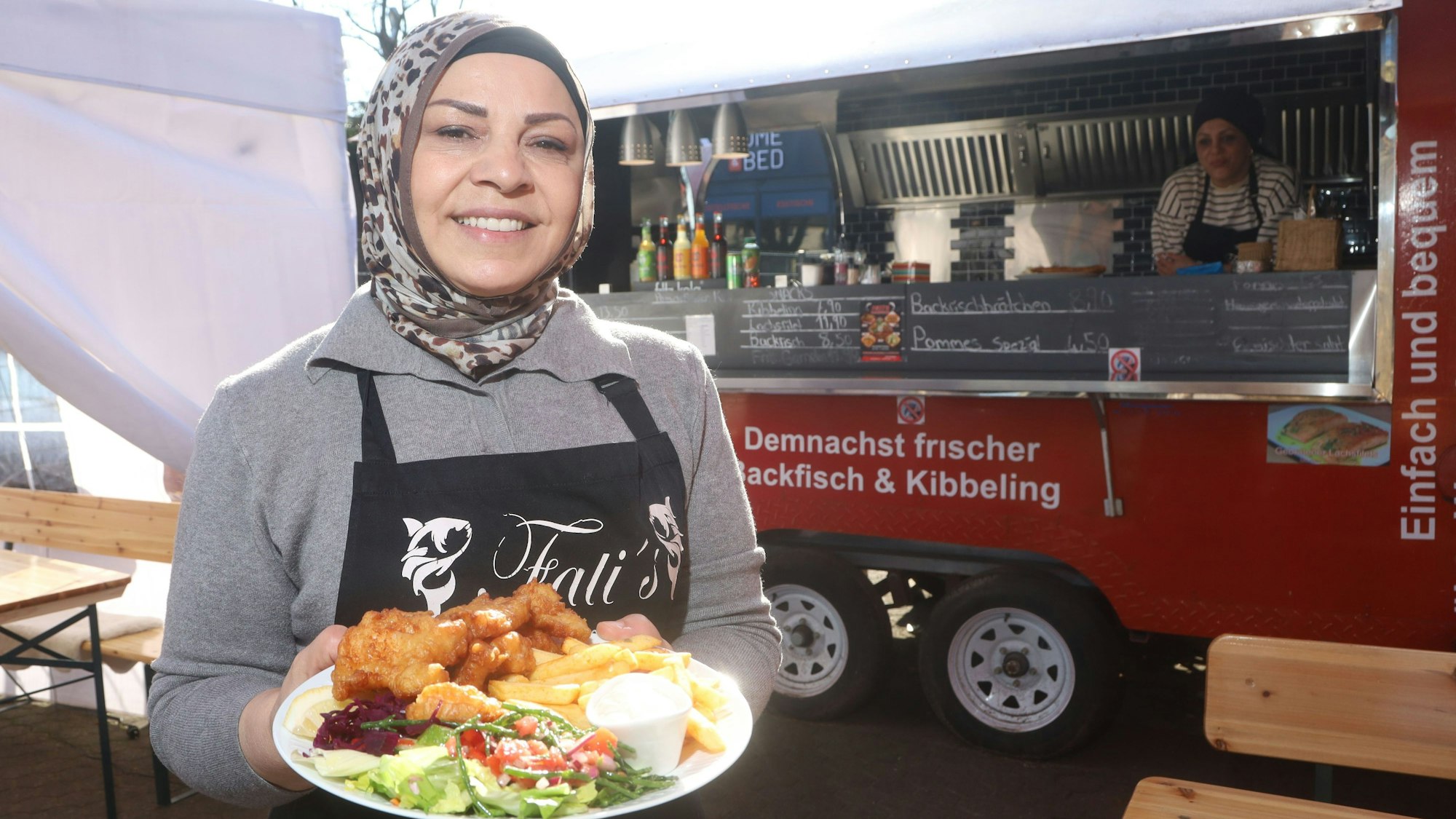 05.03.2026, Köln: Gastro-Kritik „Julias Lieblingsort“ von Julia Floß über das Restaurant „Fati's Backfisch“ in Niehl. Inhaberin Fatma Karakaya mit einem Teller Kibbeling mit Salat und Pommes. Foto: Arton Krasniqi