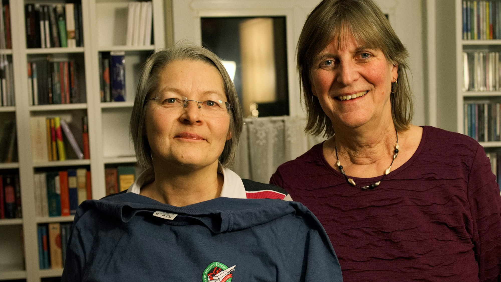 Anne Meyer (links) und Dagmar Buchendorfer stehen nebeneinander vor einem Bücherregal.