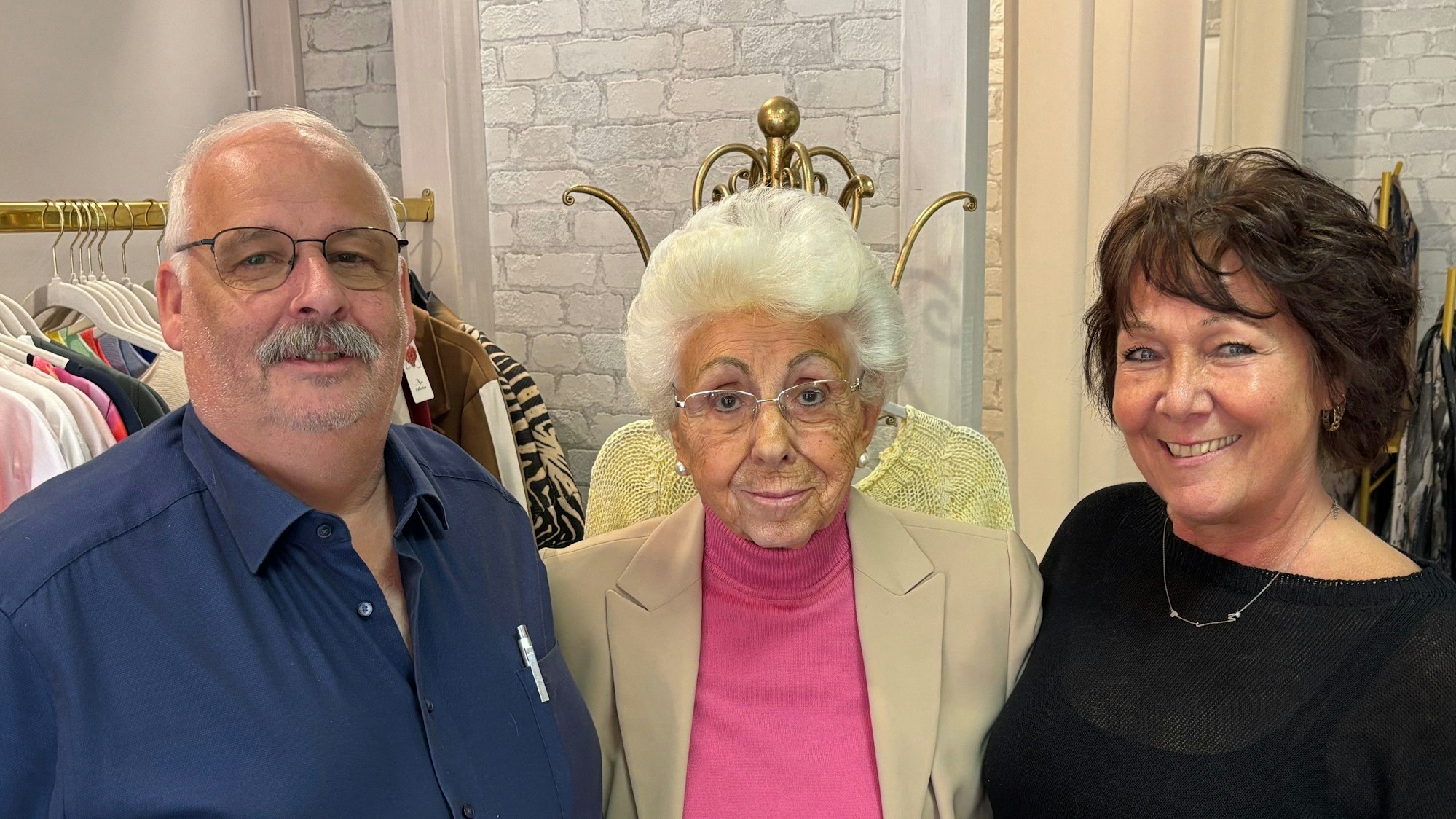 Auf dem Bild sind zwei Frauen und ein Mann in einer Boutique zu sehen.