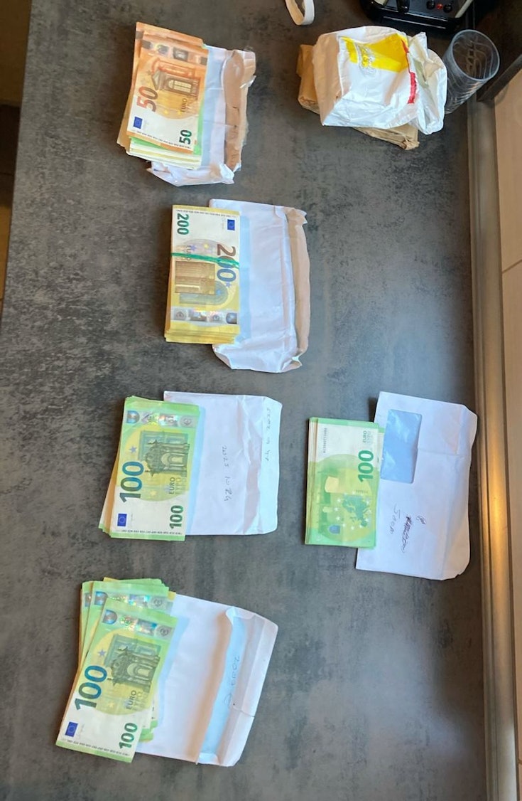 Ein großer Haufen Bargeld liegt auf einem Tisch.