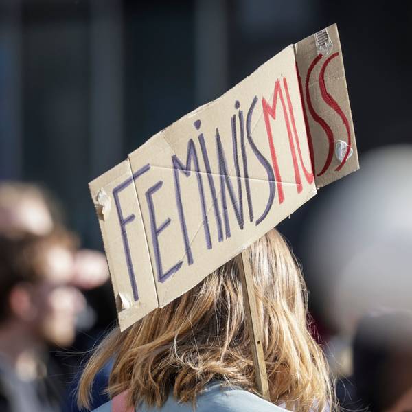 Ein Teilnehmerin einer Demonstration zum Weltfrauentag trägt ein Schild mit der Aufschrift «Feminis-muss».