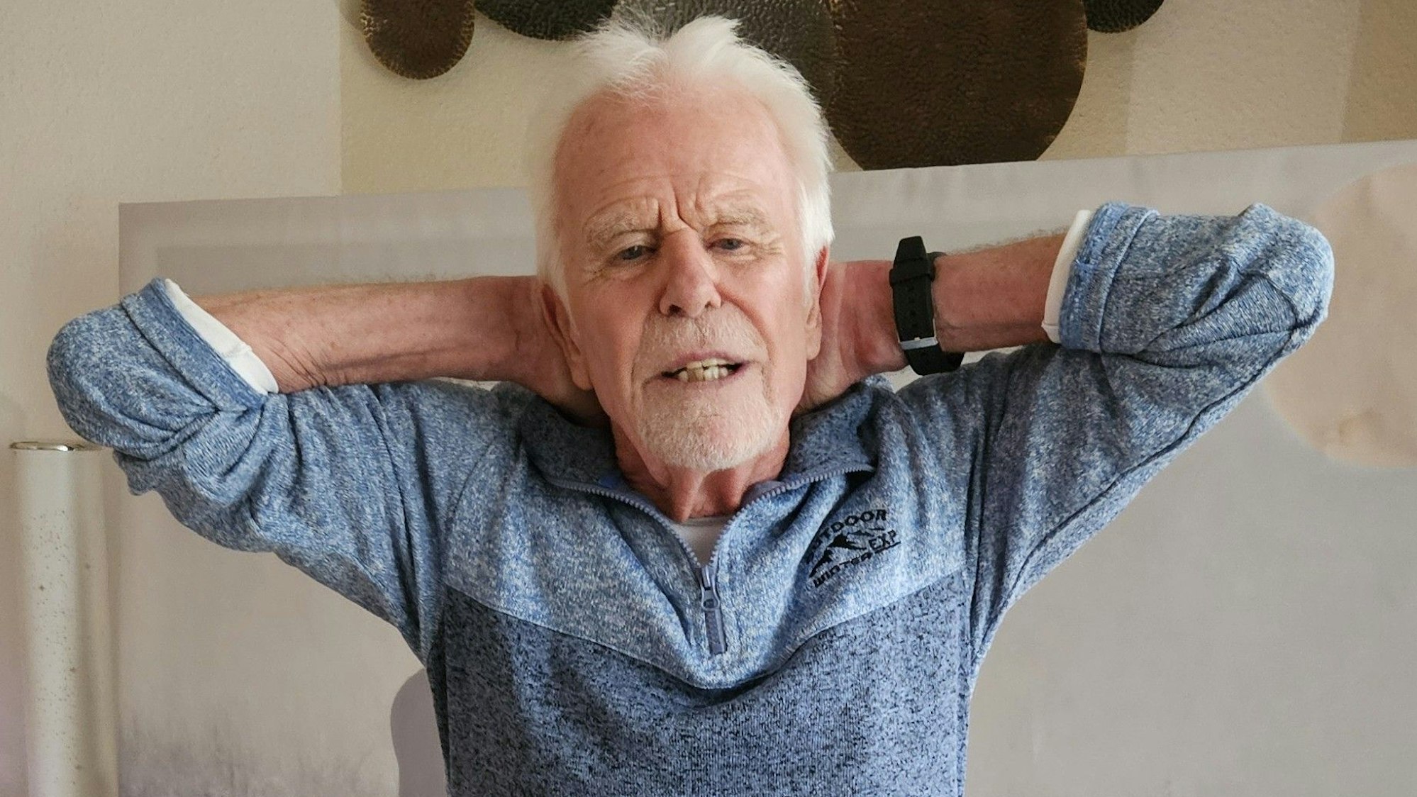 Ein Mann legt seine Hände in den Nacken.