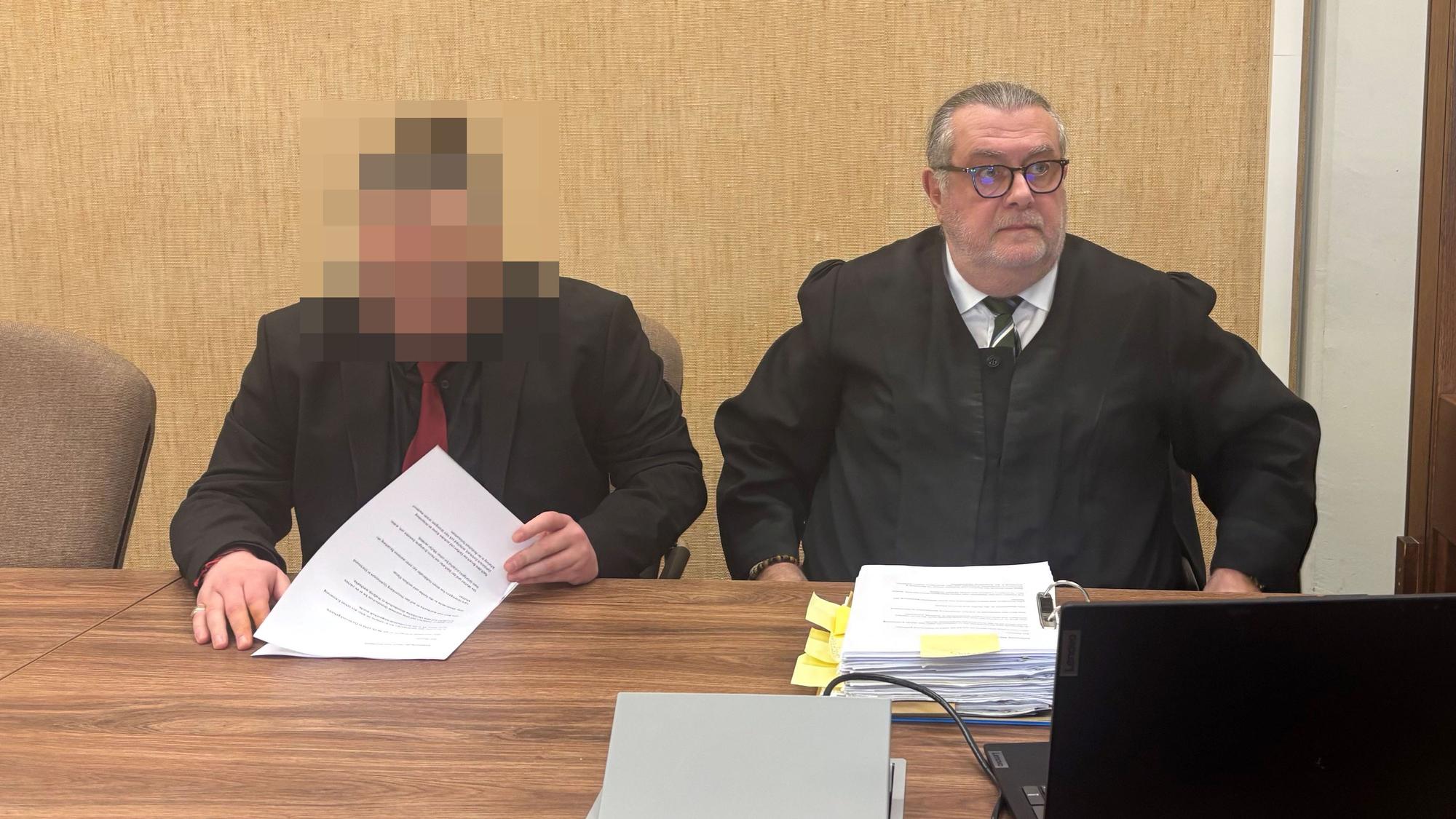 Der Angeklagte im schwarzen Anzug sitzt neben Verteidiger Thomas Düber.