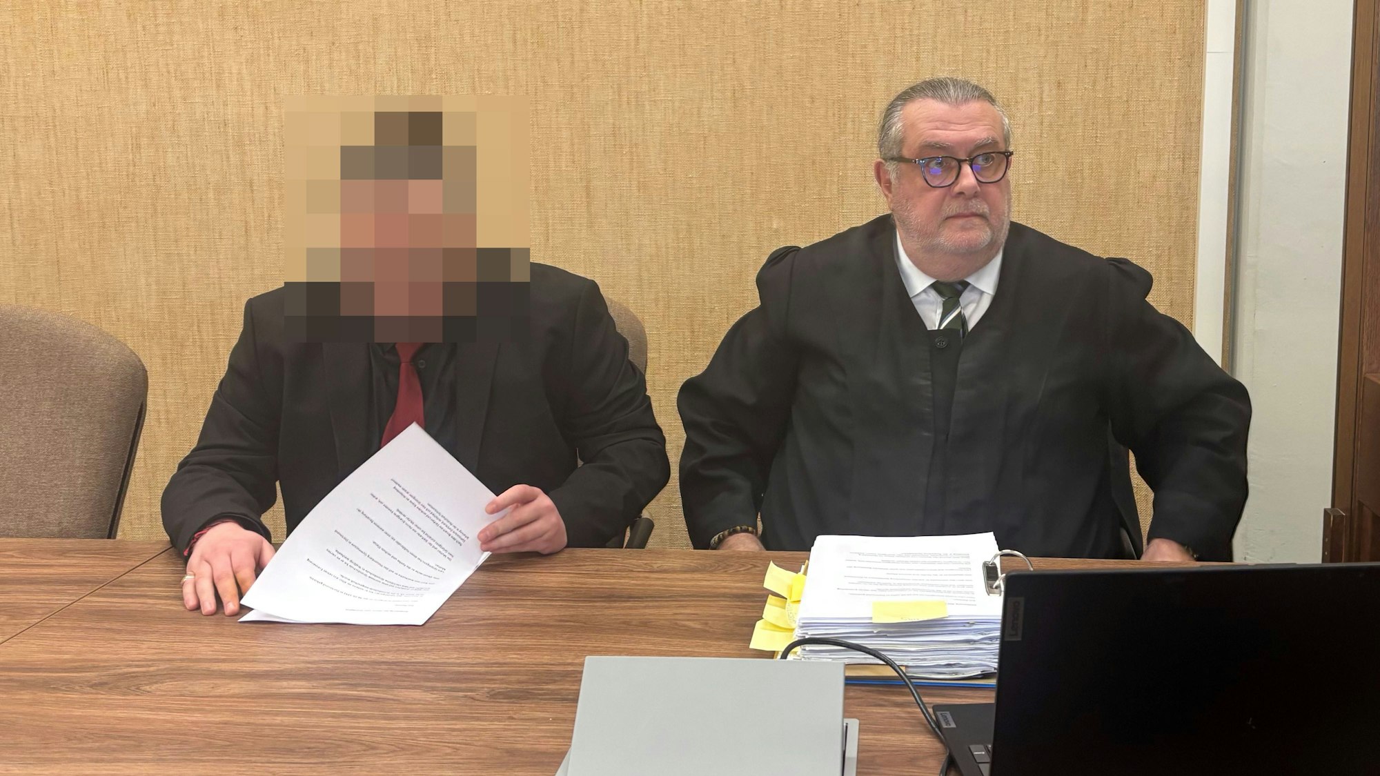 Der Angeklagte im schwarzen Anzug sitzt neben Verteidiger Thomas Düber.