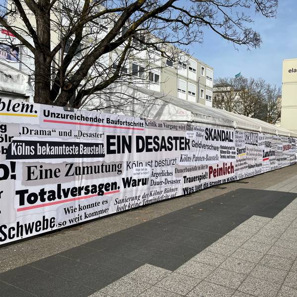 „Totalversagen“ oder „Desaster“: Der sogenannte „Frustzaun“ an der Bühnen-Baustelle am Offenbachplatz zeigt Schlagzeilen der vergangenen 14 Jahre.