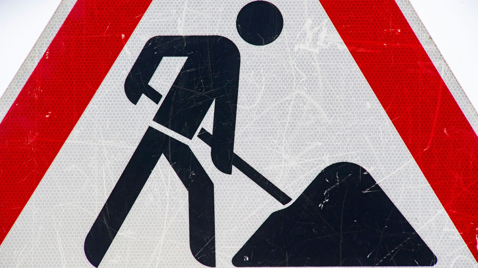 Ein Baustellenschild steht an einer Straße.