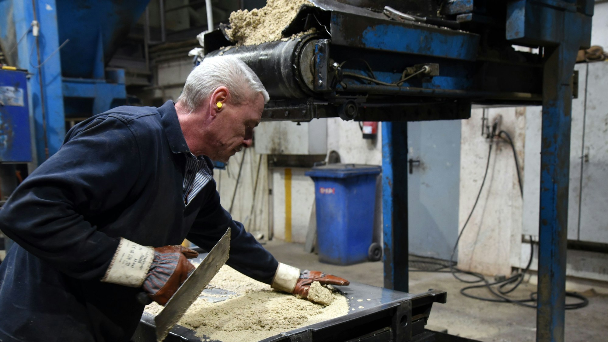 Ein Mitarbeiter fertigt im Gewerbe- und Industriegebiet von Waldbröl-Hermesdorf gerundete Zwischen-Simse aus Beton für die bekannten Gartengrillkamine des Familienunternehmens Buschbeck.