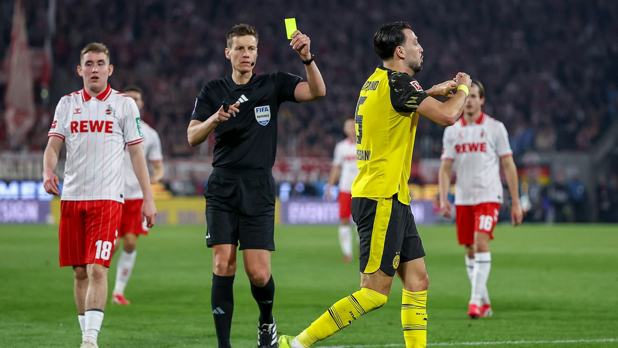 Daniel Siebert zückt beim Spiel zwischen Köln und dem BVB eine Gelbe Karte.