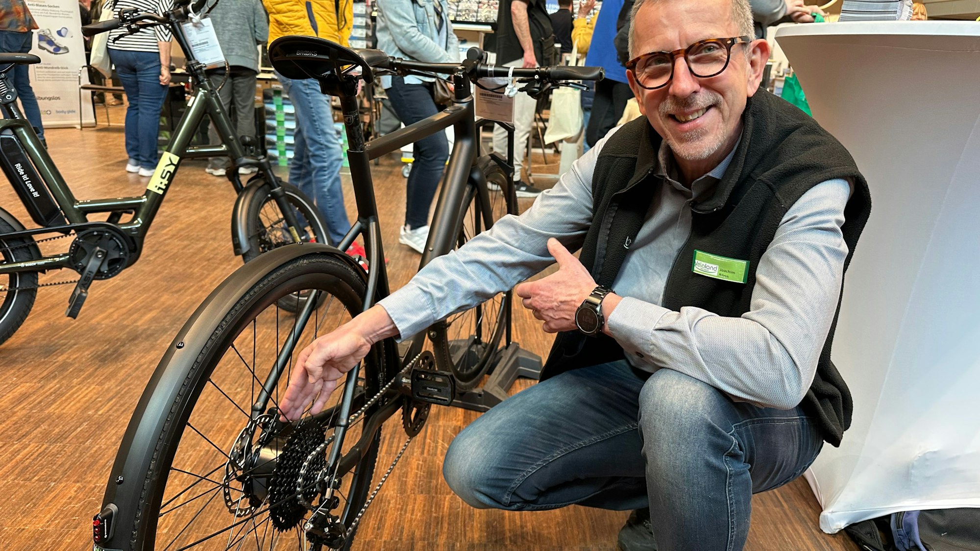 Joachim Rönn von Veloland zeigt auf ein City-Bike mit Motor im Hinterrad.