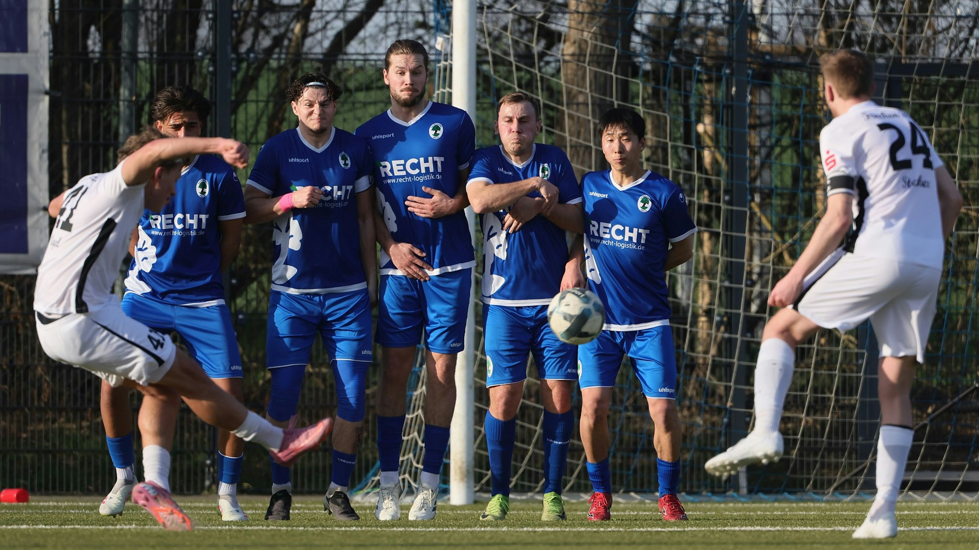 Das Foto zeigt den Schützen von Frechen 20 von hinten, der den Freistoß an der Mauer vorbeizirkelt.