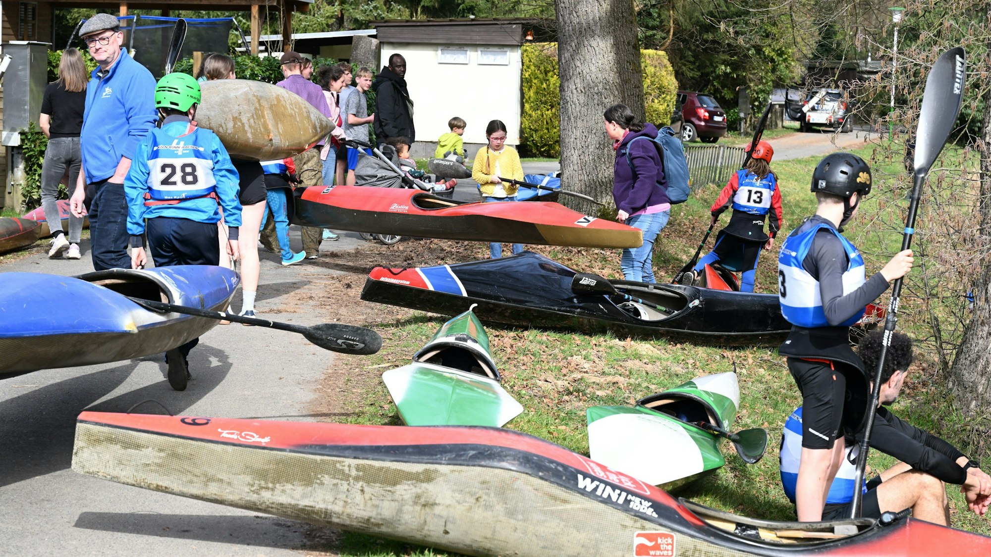 Eine Gruppe Kanufahrer steht am Ufer bei ihren Kanus und macht sich bereit.