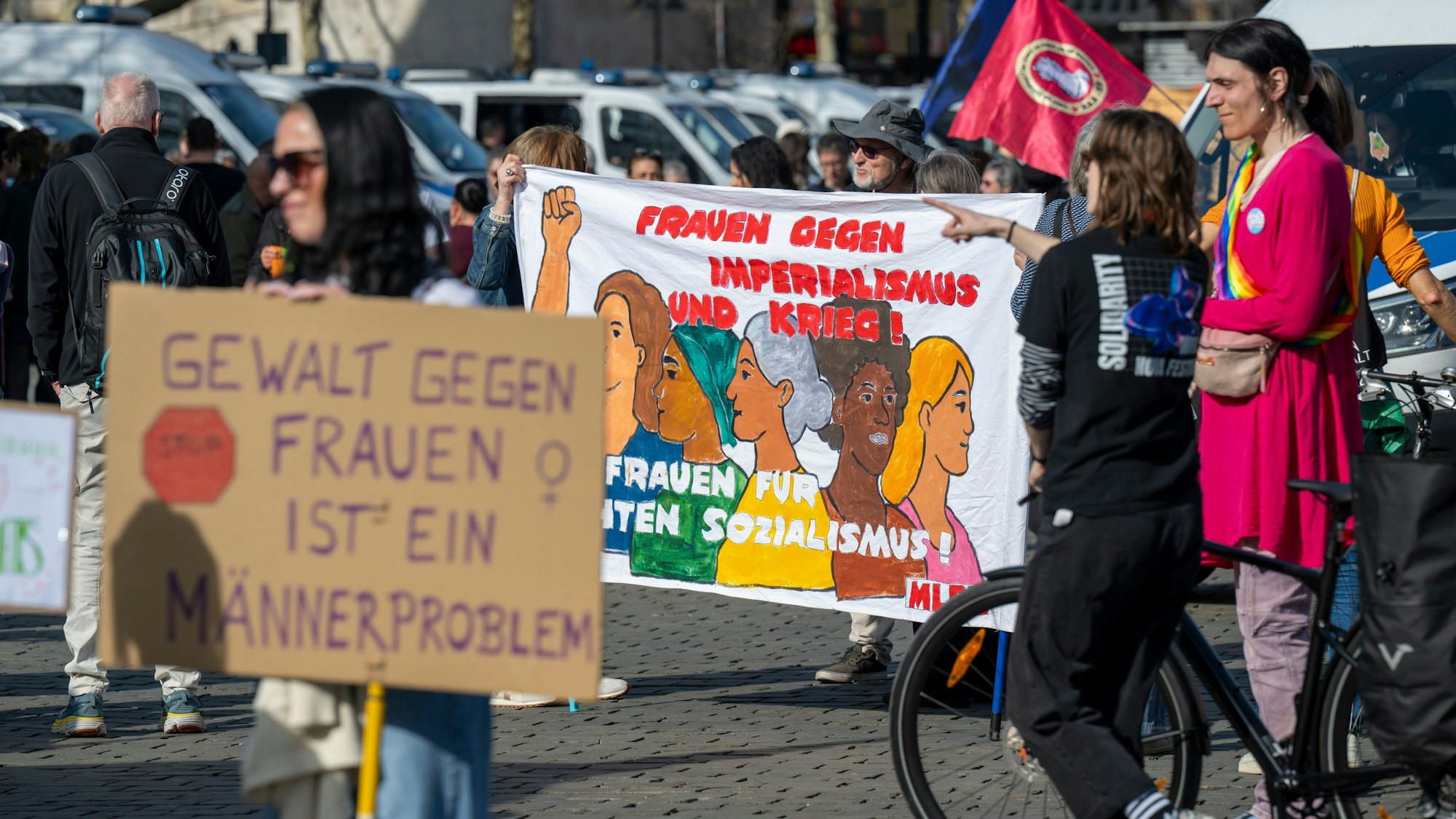 Am Weltfrauentag findet auf dem Heumarkt eine Demonstration statt. „Gewalt gegen Frauen ist ein Männerproblem“, steht auf einem Plakat im Vordergrund.