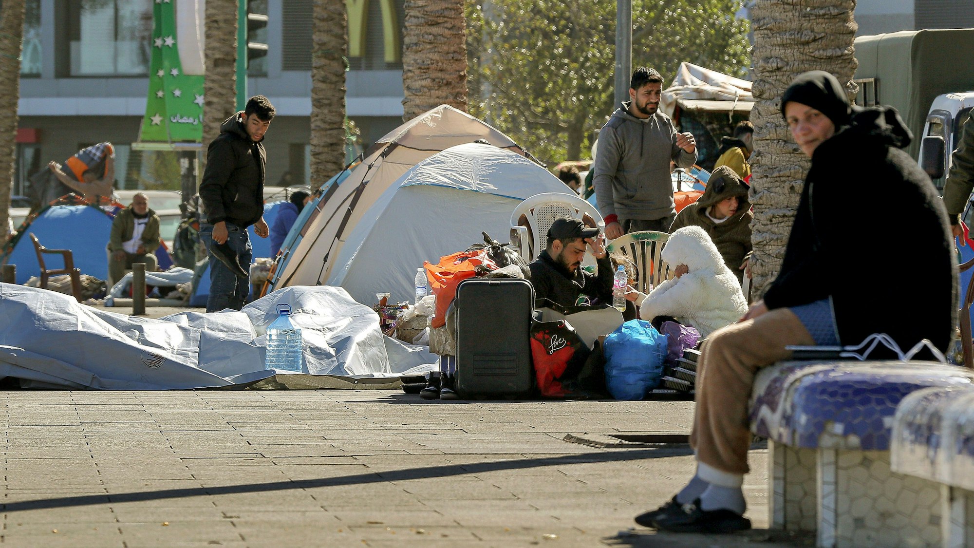 Libanesische Zivilisten, die aus den südlichen Vororten von Beirut geflohen sind, sitzen in der Nähe von Zelten, die auf dem Bürgersteig entlang der Strandpromenade von Beirut errichtet wurden.