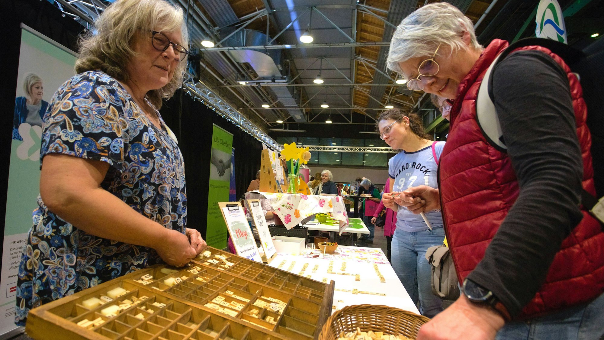Am Stand des Kontaktbüros Pflegeselbsthilfe der Paritätischen lässt Dorit Knabe Besucherinnen aus Scrabble-Steinen Worte legen, die pflegenden Angehörigen durch den Kopf gehen.
