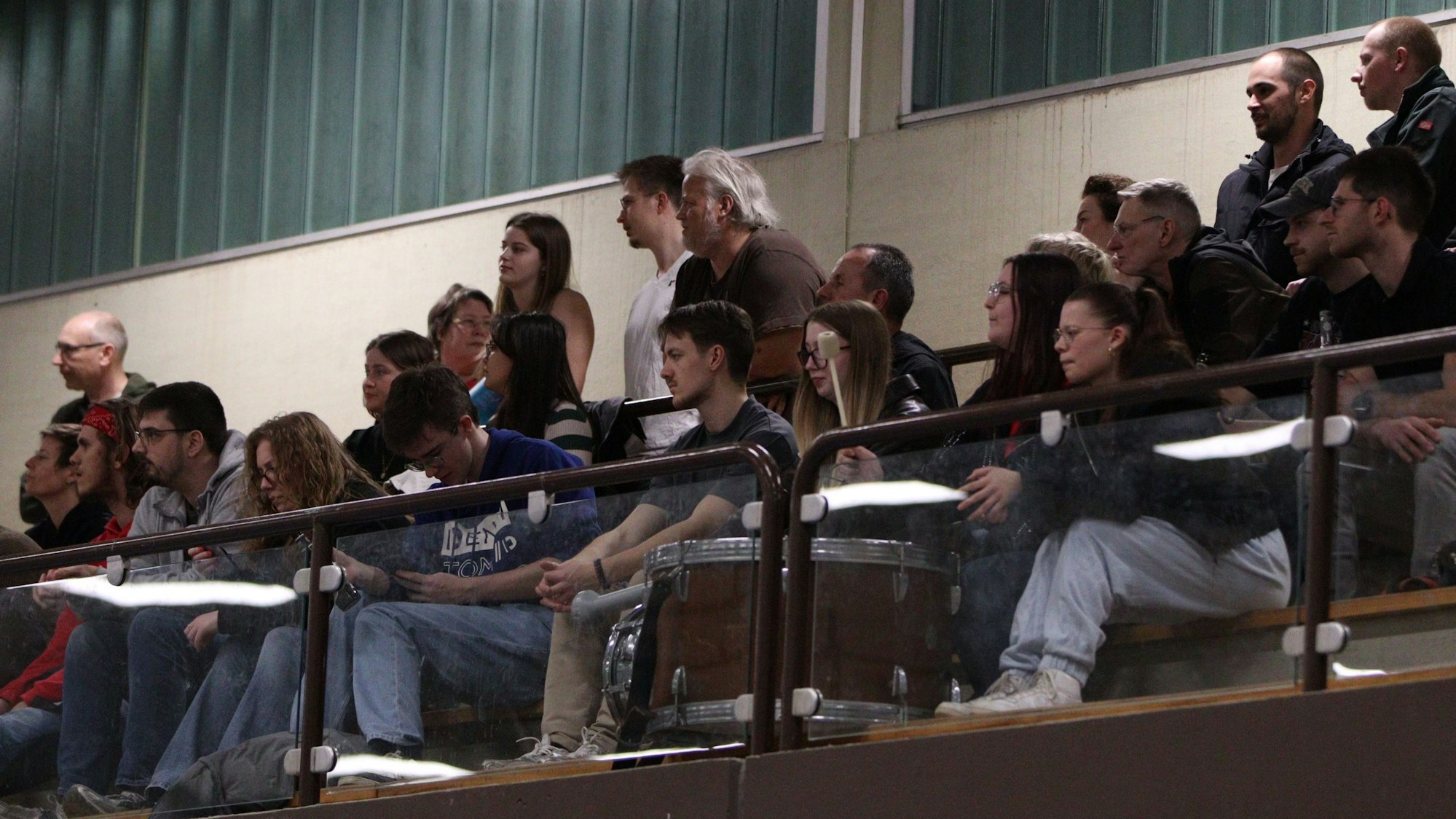 Zuschauer auf der Tribüne, einige von ihnen haben Trommeln.