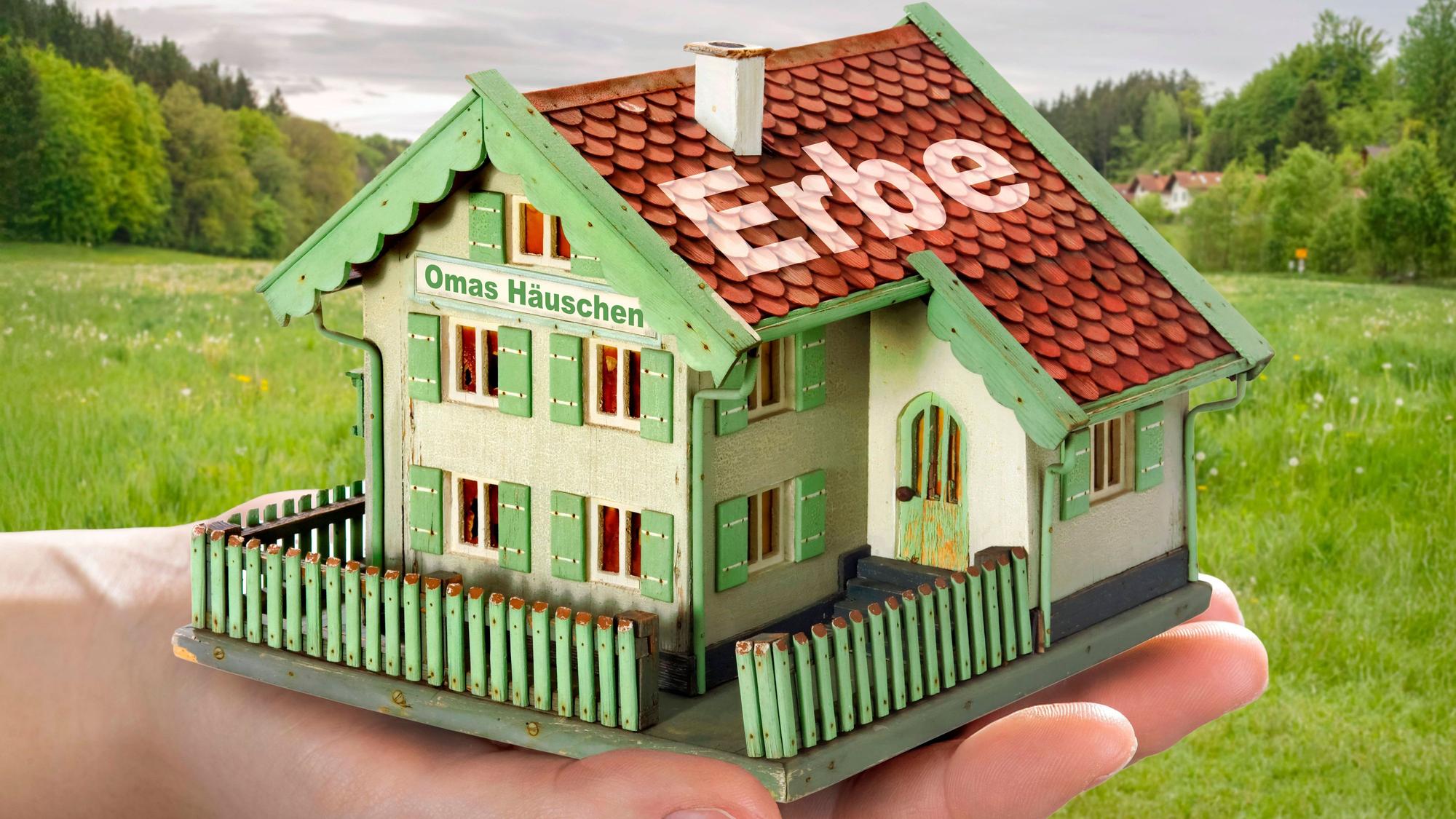 Ein Spielzeug-Häuschen mit dem Wort "Erbe" auf dem Dach.