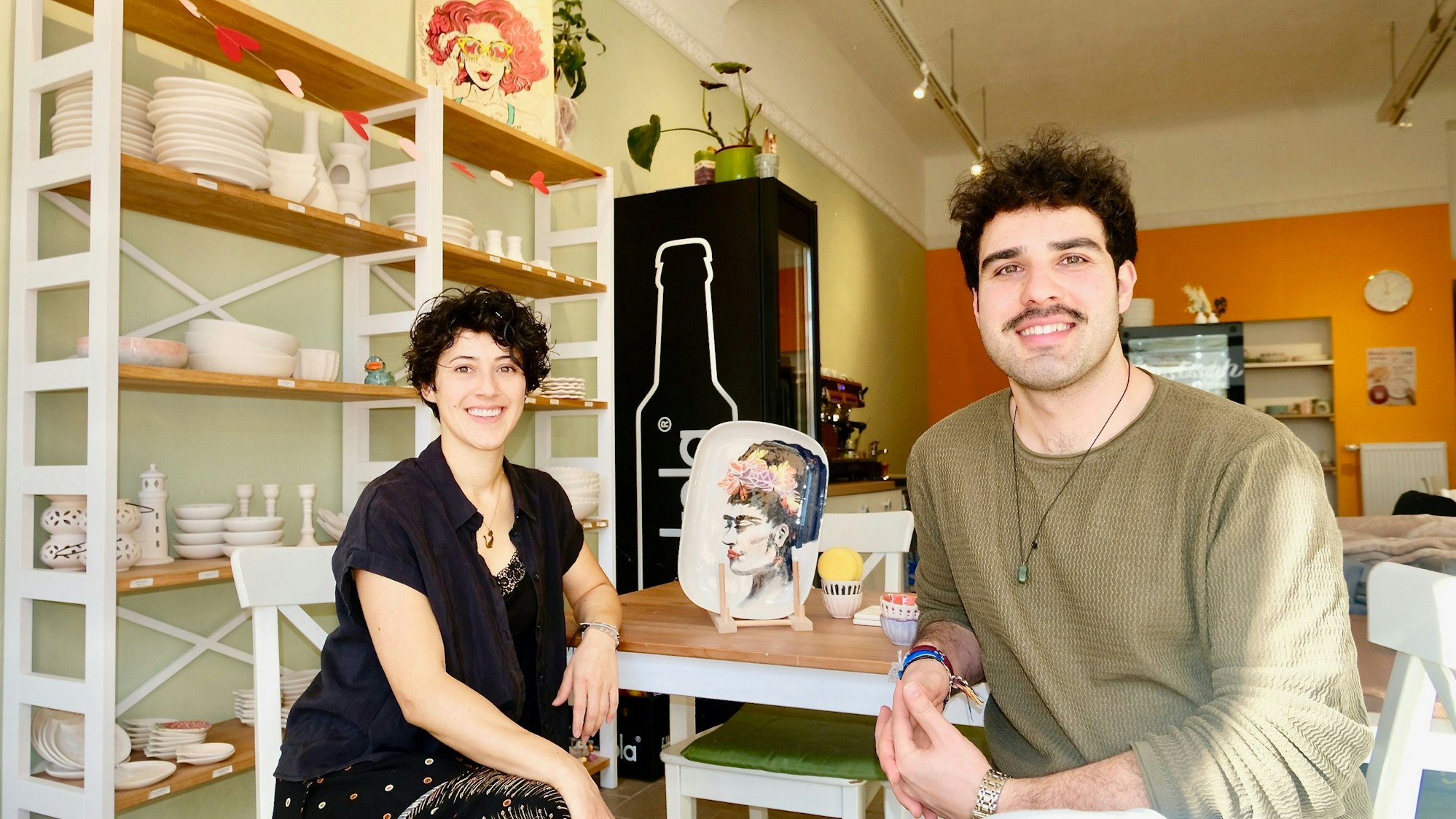 Eine Frau und ein Mann sitzen an einem Holztisch.