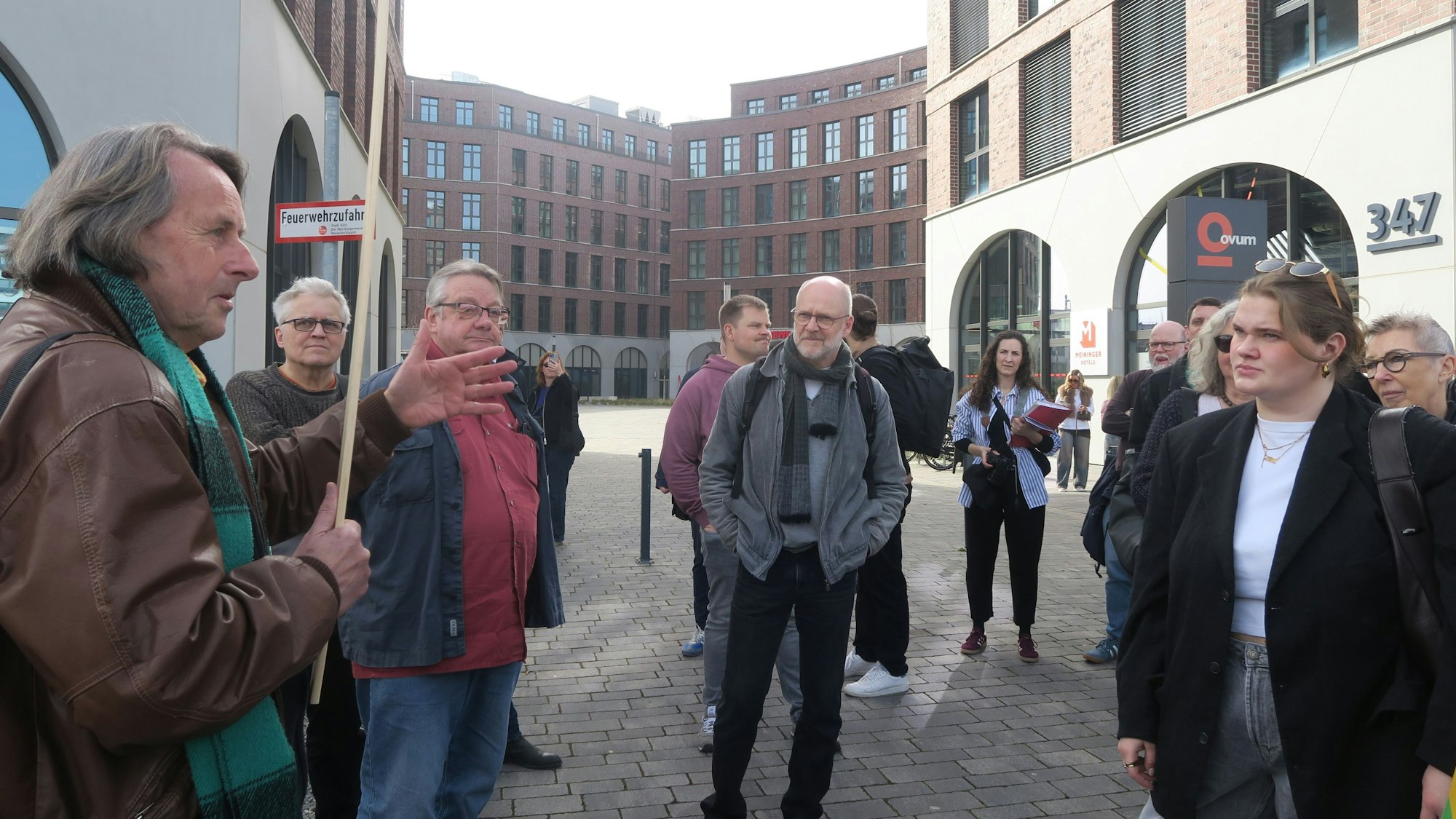 Ein Mann erklärt einer Gruppe Menschen etwas.