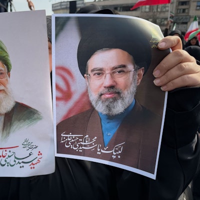 Eine Frau hält Plakate von Ayatollah Modschtaba Chamenei (r.), dem Nachfolger seines getöteten Vaters, Ayatollah Ali Chamenei (l) als Oberster Führer, während einer Kundgebung zu seiner Unterstützung in Teheran.