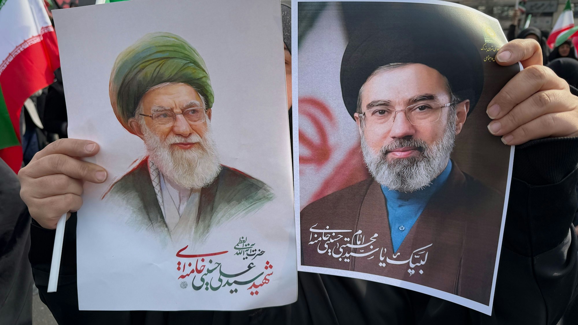 Eine Frau hält Plakate von Ayatollah Modschtaba Chamenei (r.), dem Nachfolger seines getöteten Vaters, Ayatollah Ali Chamenei (l.) als Oberster Führer, während einer Kundgebung zu seiner Unterstützung in Teheran.