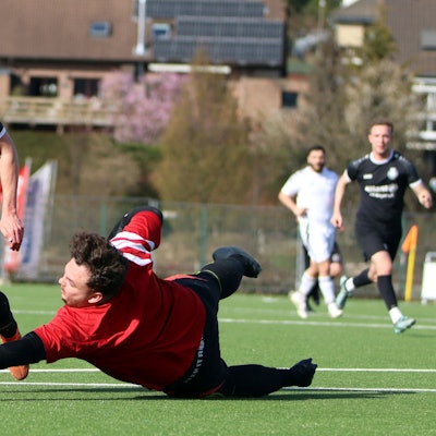 DHO-Torwart Bastian Hilbert macht sich lang, bekommt seine Finger aber nicht mehr an den Ball, mit dem Tom Lengersdorf ihn ausspielt.