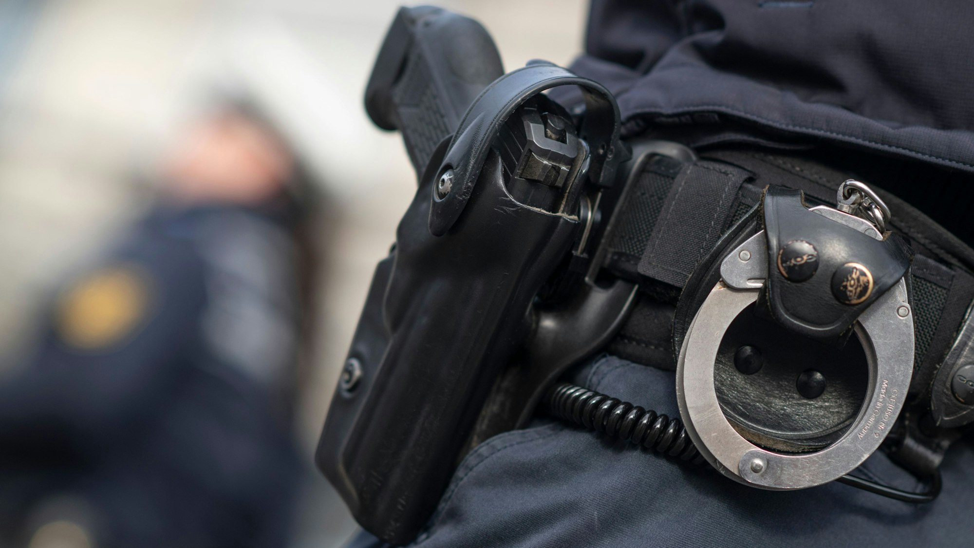 Ein Polizist und eine Polizistin der Polizei Baden-Württemberg stehen in einem Industriegebiet.