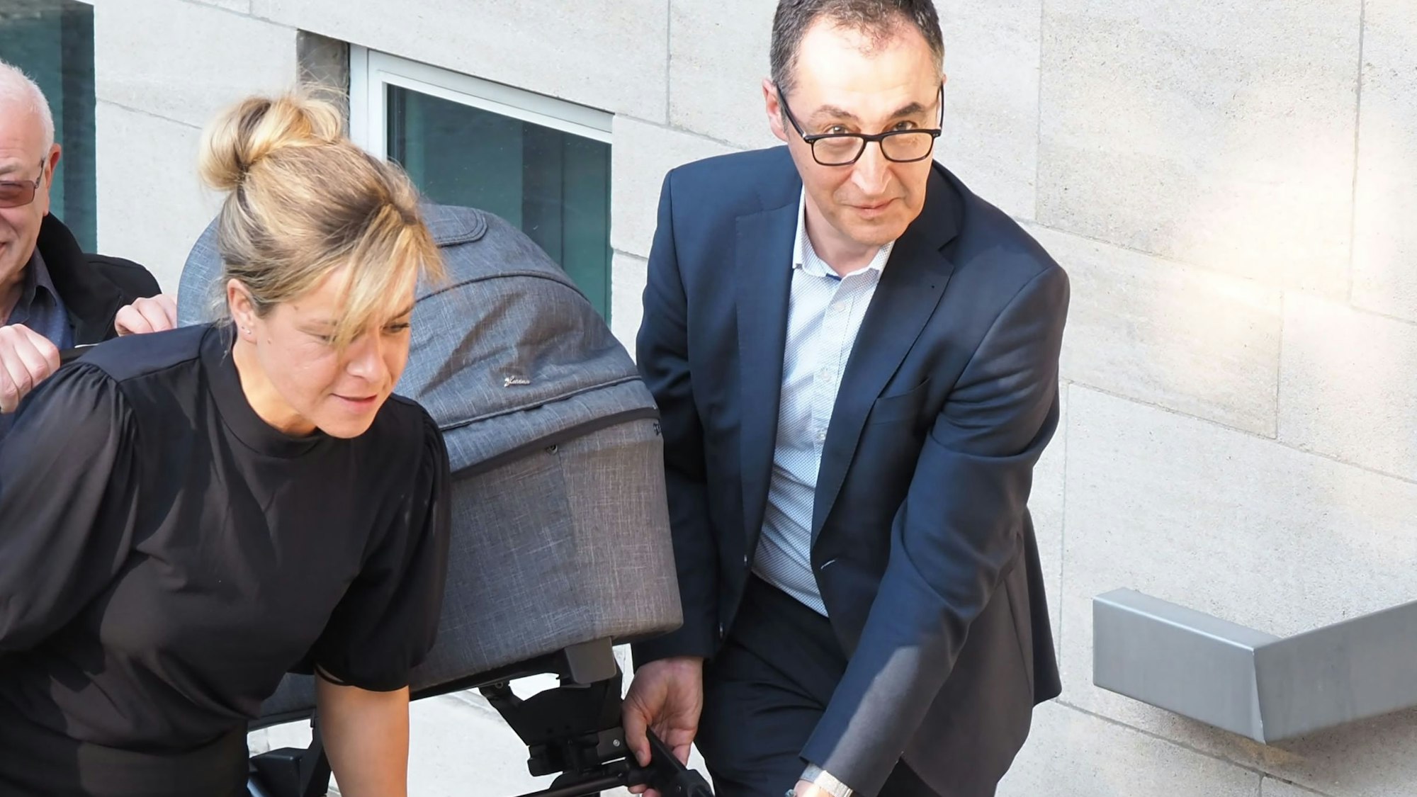 Mona Neubaur und Cem Özdemir tragen 2022 den Kinderwagen einer Parteifreundin.