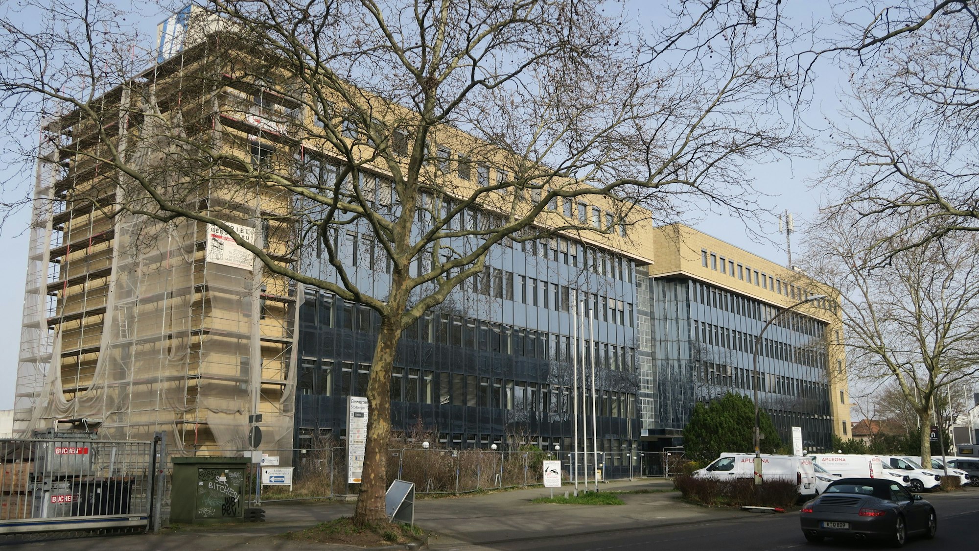 An einer Straße steht ein mehrstöckiges Gebäude.